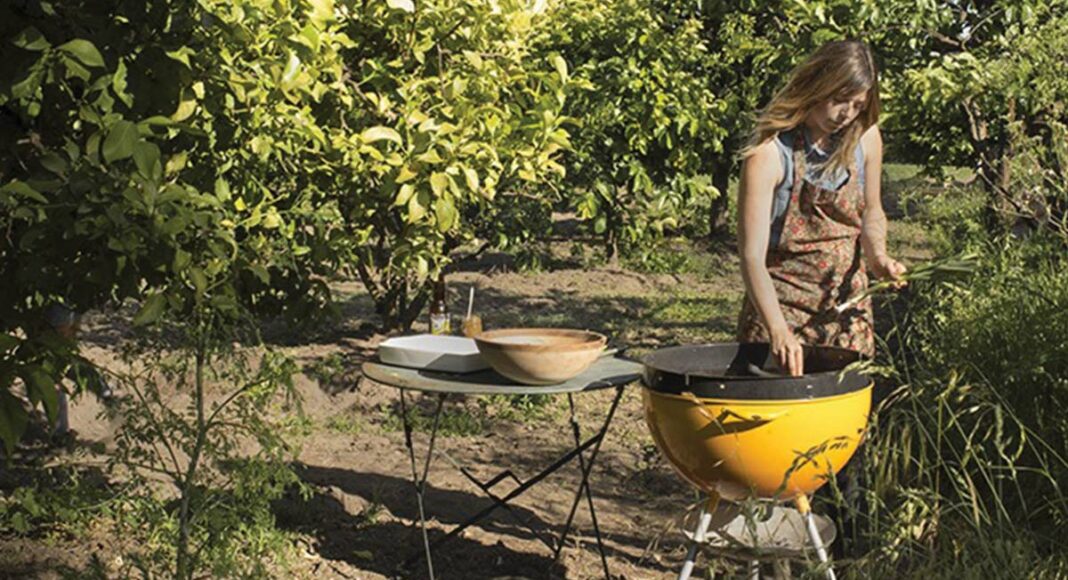 Laura Freed of Wilder Condiments grilling in an orchard