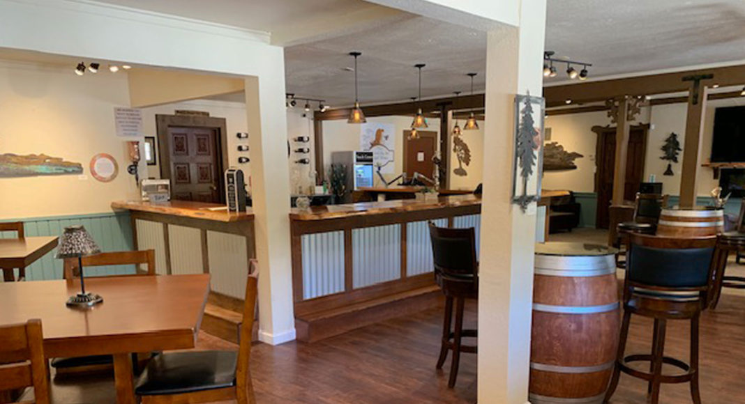 Empty tasting room with bar, wine barrel and tables