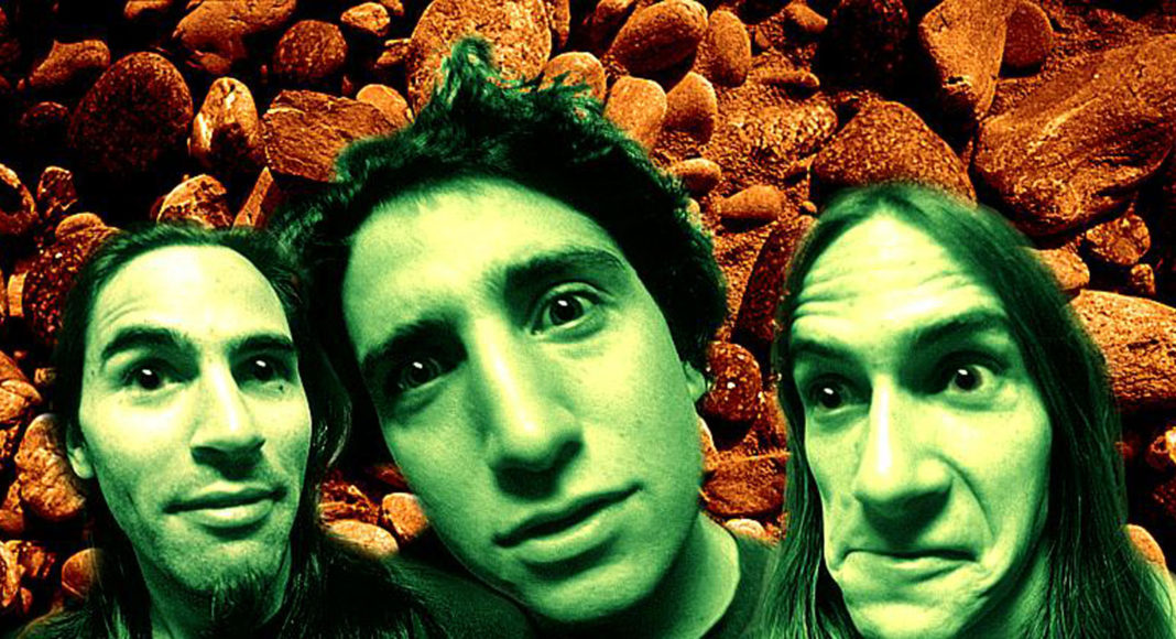 Distorted, green-tinged faces against a brown background