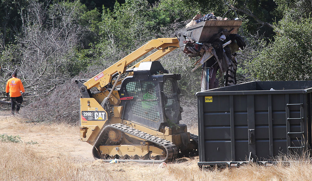 Heavy equipment being used to move homeless encampments