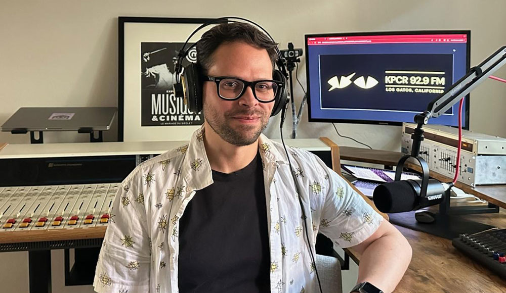 Man with headphones in front of computer screens