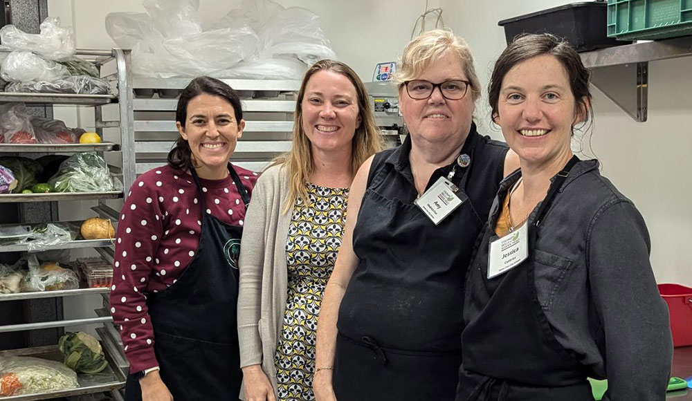 Four women standing in a kitchen