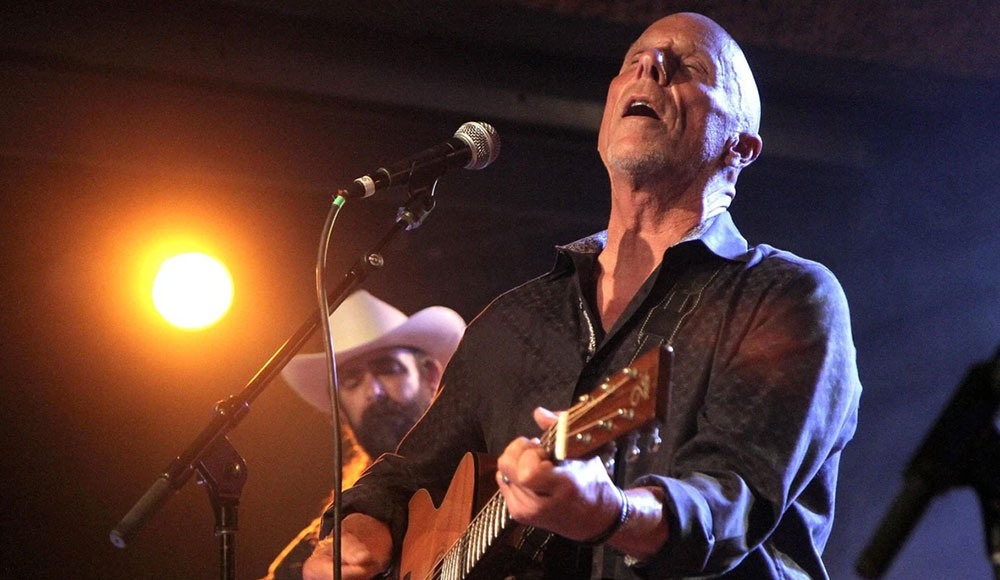 Tim Flannery performs onstage under the spotlight