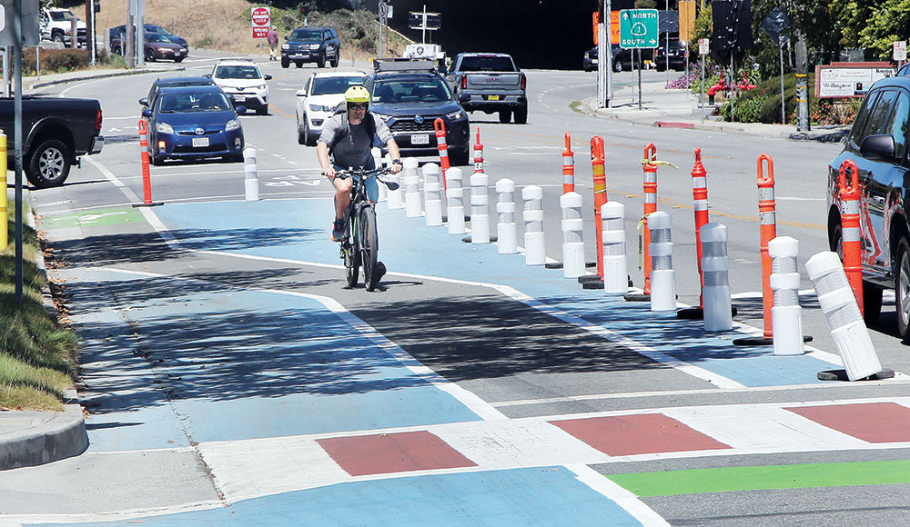 Street with various zones of the pavement painted different colors (blue, green, and white-and-red stripes)