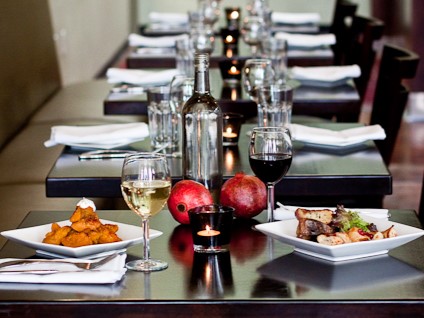 Plated entrees and glasses of wine at Laili restaurant.