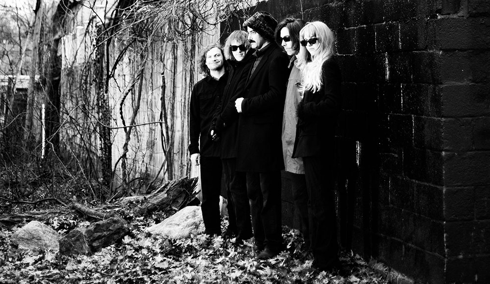 Group of people standing in front of a spooky house