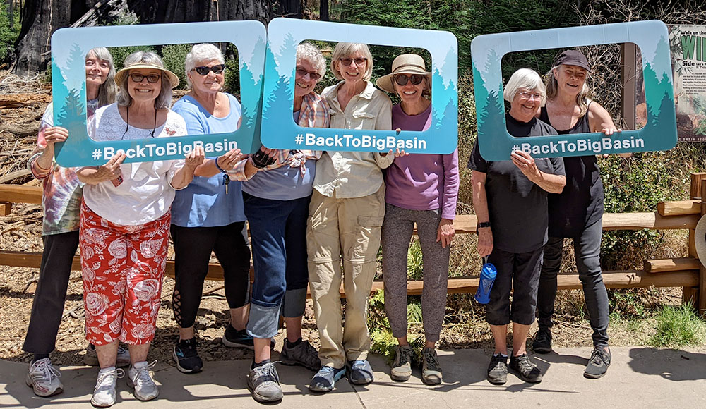 Group of people holding up signs that frame their faces and say 