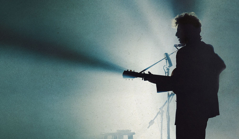 Man playing the guitar on stage, in silhouette