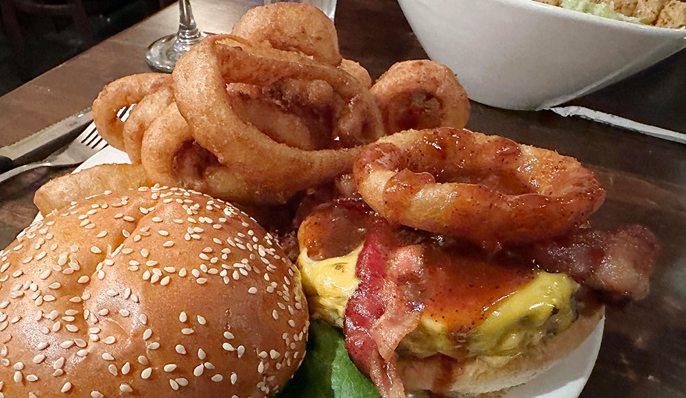 Burger topped with onion rings and cheese