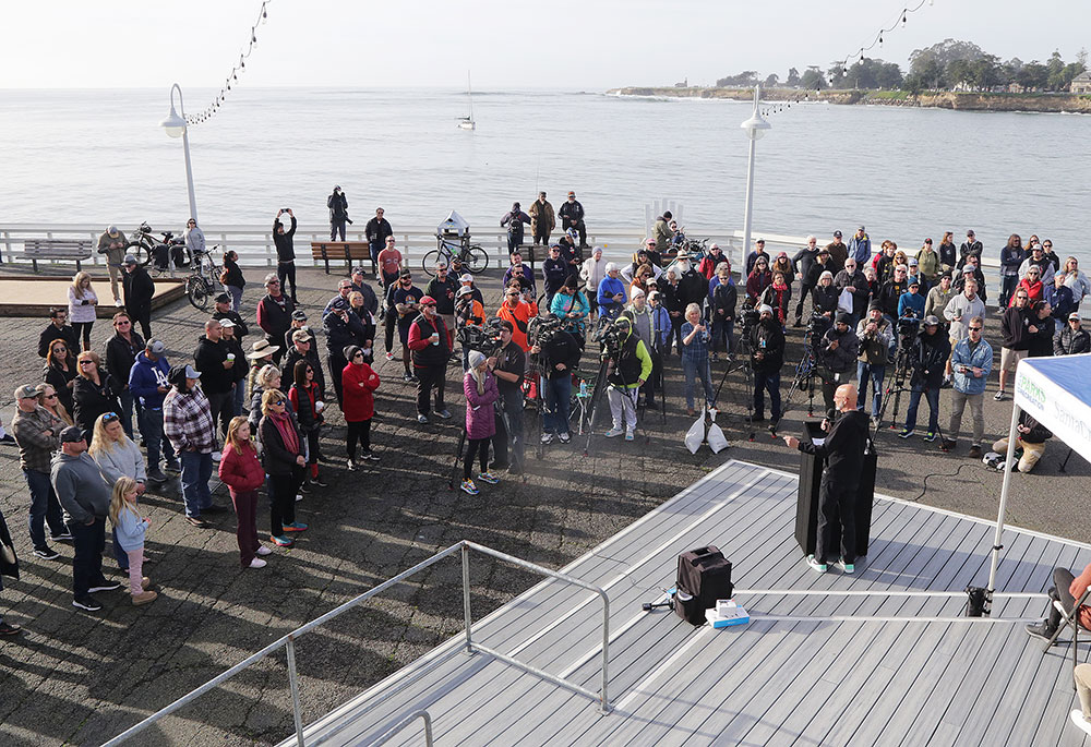 Crowd of people on a wharf listening to speakers