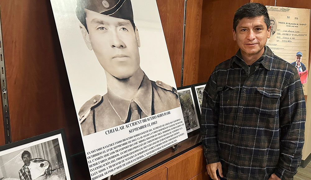 Man in front of a display with photos