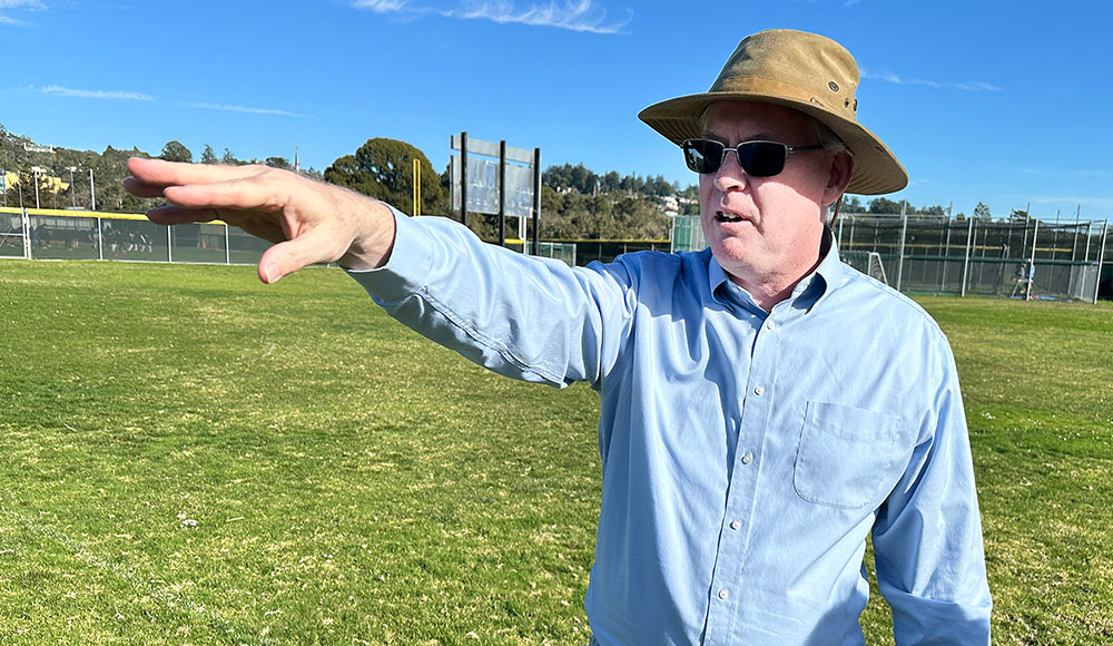 Man standing in a field with his arm raise