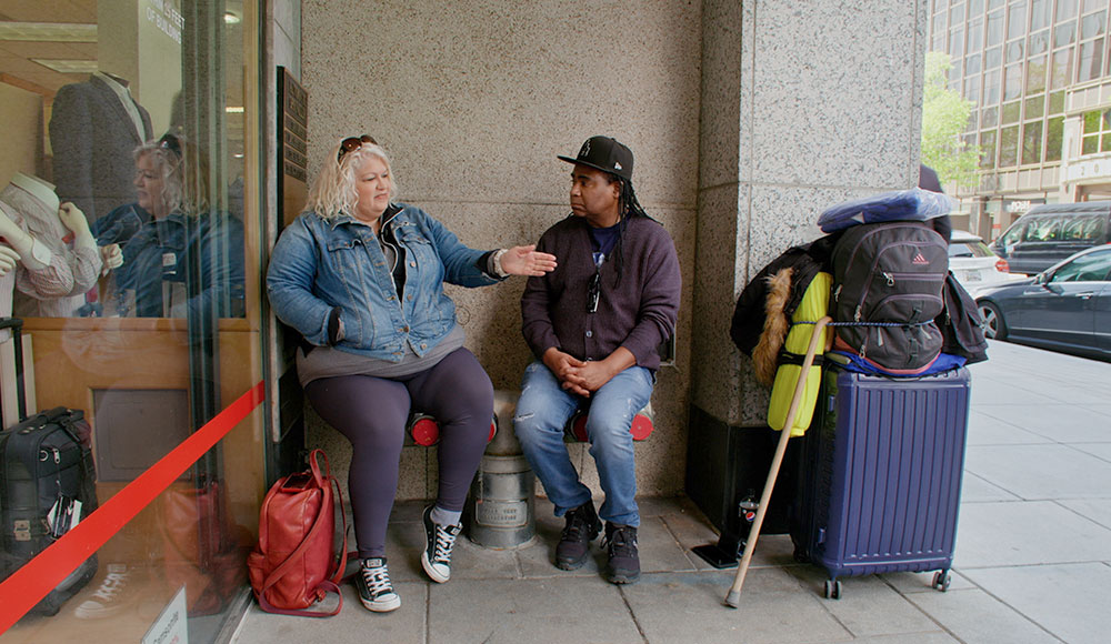 Man talking to a woman on the sidewalk