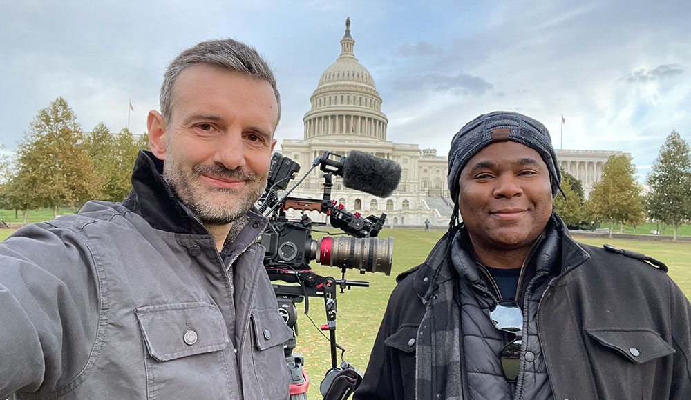 Two men standing in front of the Capitol building