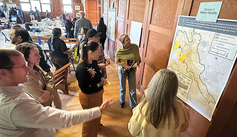 Group of people at a meeting looking at a map on the wall